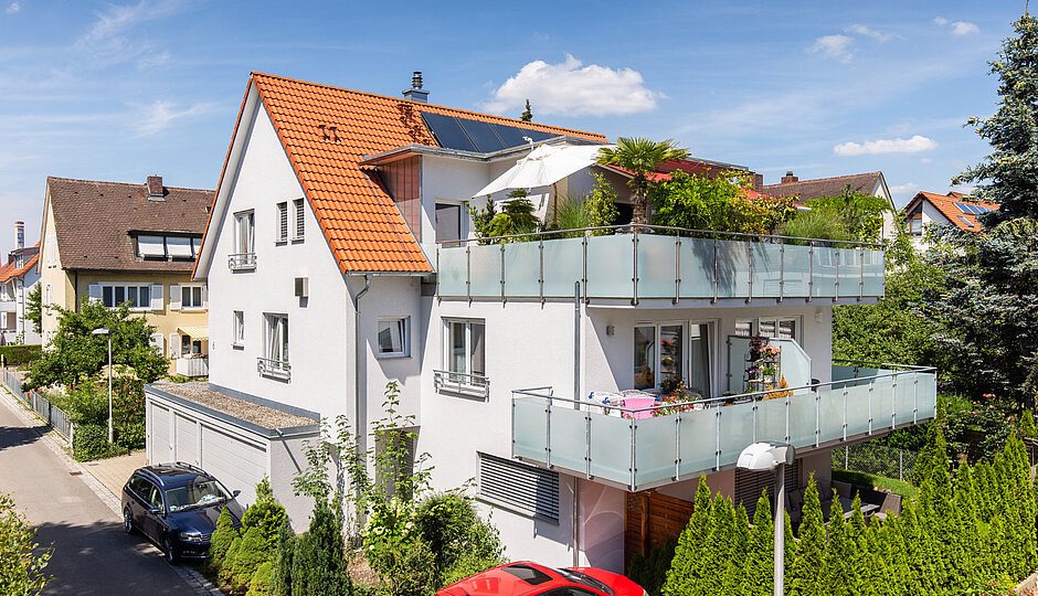Mehrfamilienhaus mit umlaufendem Balkon und Pflanzen