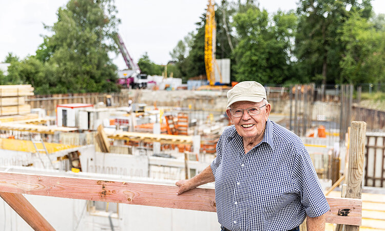 Karl Mathis von Mathis Bau steht an einem Zaun auf einer Baustelle